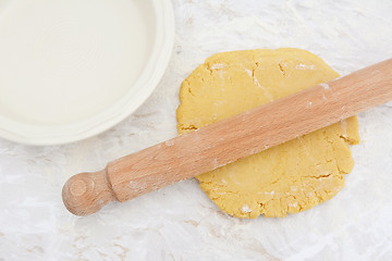 Image showing Rolling out homemade pastry with a rolling pin