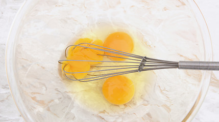 Image showing Three eggs with a wire balloon whisk