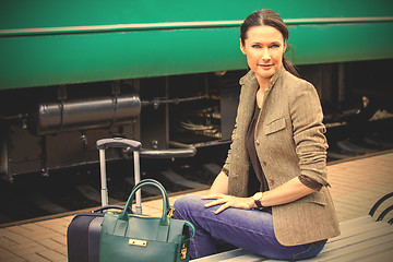 Image showing smiling beautiful woman with travel bag and a suitcase