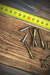 Image showing several different screws and yellow measuring tape