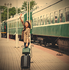 Image showing smiling beautiful middle-aged woman with a suitcase and handbag