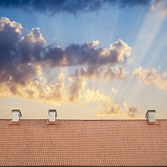 Image showing cloudy blue sky and tiled roof top