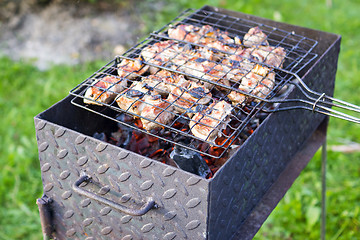 Image showing Meat on skewer frying on brazier