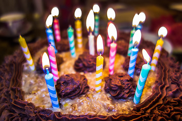 Image showing lighting Colorful candles on birthday cake  