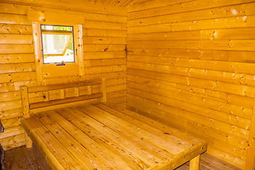 Image showing small log cabin interior with bed and window
