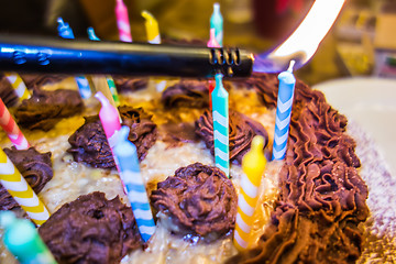 Image showing lighting Colorful candles on birthday cake  