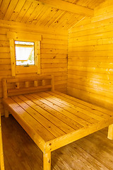 Image showing small log cabin interior with bed and window