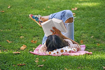 Image showing Girl reading a book in the park