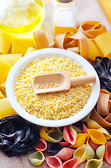 Image showing assortment of raw pasta and wheat on wooden background