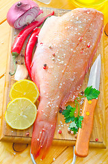 Image showing raw fish with aroma spice on wooden background