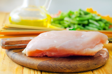 Image showing Raw chicken on the wooden board, raw chicken and raw pasta
