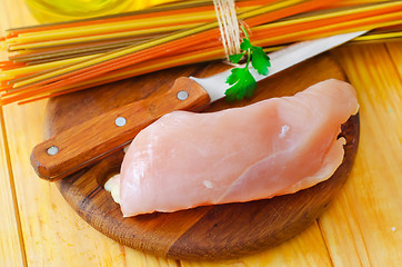 Image showing Raw chicken on the wooden board, raw chicken and raw pasta