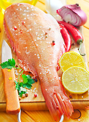 Image showing raw fish with aroma spice on wooden background