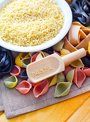 Image showing assortment of raw pasta and wheat on wooden background