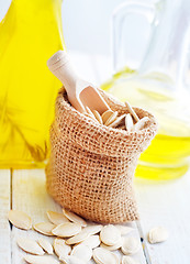 Image showing Dry pumpkin seed in sack, oil in glass bottle