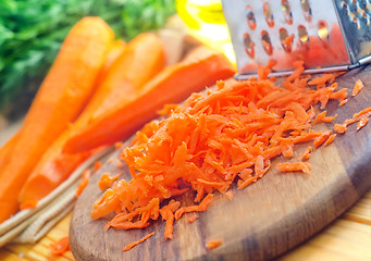 Image showing raw carrots and knife on the wooden board