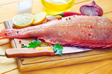 Image showing raw fish with aroma spice on wooden background