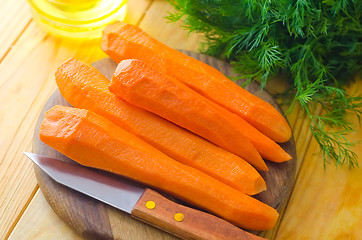 Image showing raw carrots and knife on the wooden board