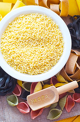 Image showing assortment of raw pasta and wheat on wooden background