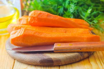 Image showing raw carrots and knife on the wooden board