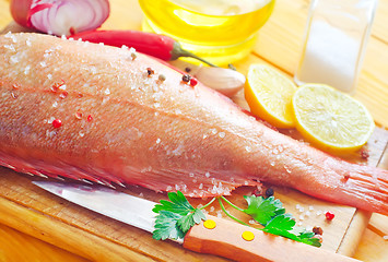 Image showing raw fish with aroma spice on wooden background