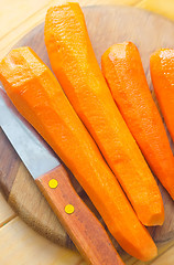 Image showing raw carrots and knife on the wooden board