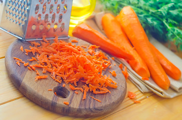 Image showing raw carrots and knife on the wooden board