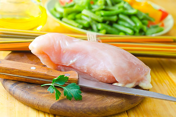 Image showing Raw chicken on the wooden board, raw chicken and raw pasta