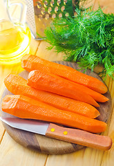 Image showing raw carrots and knife on the wooden board