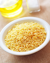 Image showing assortment of raw pasta and wheat on wooden background