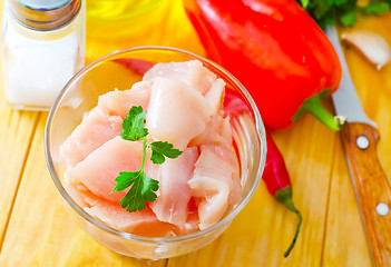 Image showing raw chicken and raw vegetables on wooden table