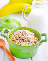 Image showing Oat flakes in the green bowl with banana and milk