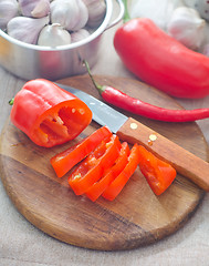 Image showing Raw red peppers on the wooden board