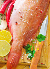 Image showing raw fish with aroma spice on wooden background