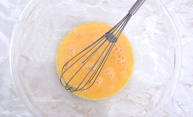 Image showing Whisk in a bowl of beaten eggs 