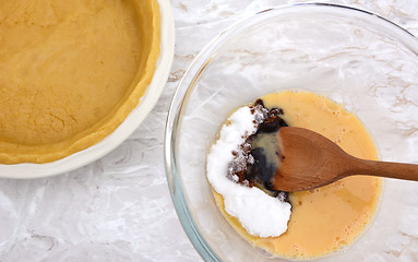 Image showing Stirring sugar into beaten egg for pumpkin pie filling