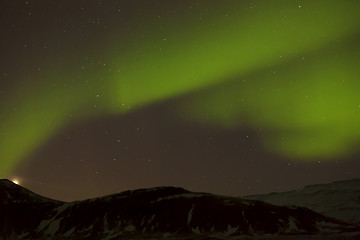 Image showing Northern lights with snowy mountains in the foreground