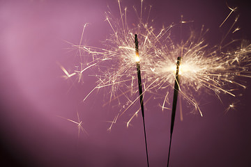 Image showing Burning sparklers on pink background
