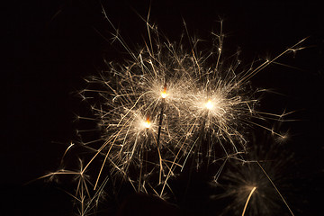 Image showing Burning sparklers on black background