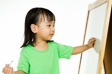 Image showing Chinese little girl writing on whiteboard