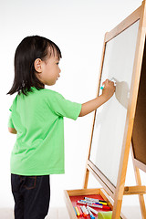 Image showing Chinese little girl writing on whiteboard