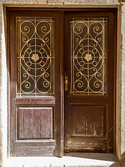 Image showing old ragged shabby wooden door with wrought iron bars