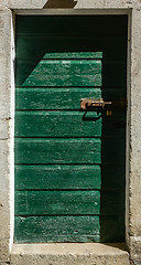 Image showing old green ragged shabby wooden door