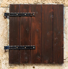 Image showing old window with  closed brown  wooden shutters