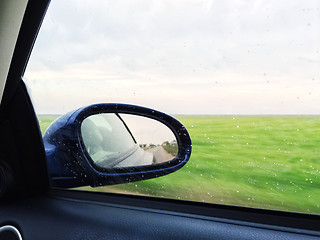 Image showing View over green fields from a modern car