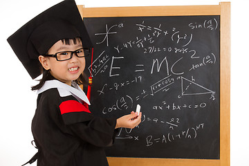 Image showing Asian Chinese little girl in graduation gown againts blackboard 