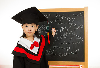 Image showing Asian Chinese little girl in graduation gown againts blackboard 