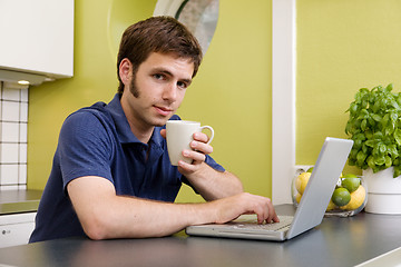 Image showing Young Man with Warm Drink at Computer