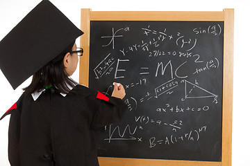 Image showing Asian Chinese little girl in graduation gown againts blackboard 