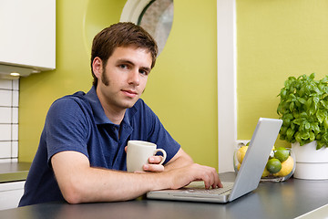 Image showing Young Man with Warm Drink at Computer